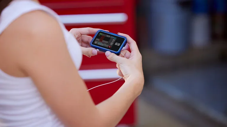 Diabetes Patientin mit der t:slim X2 Insulinpumpe in der Hand