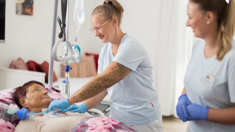 Außerklinische Intensivpflegerin mit Patientin am Bett