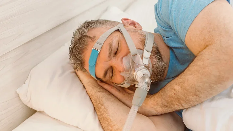 Ein Mann liegt mit einer Sauerstoffmaske auf einem Bett