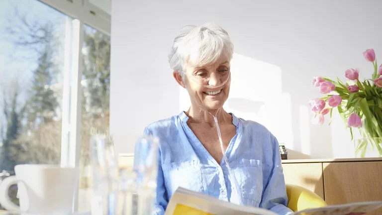 Ältere Frau mit COPD bekommt Sauerstoff über einen Schlauch