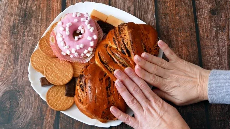 Hände schieben süßes Gebäck beiseite