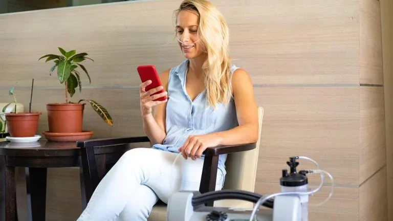 Junge Frau am Handy mit Beatmungsgerät