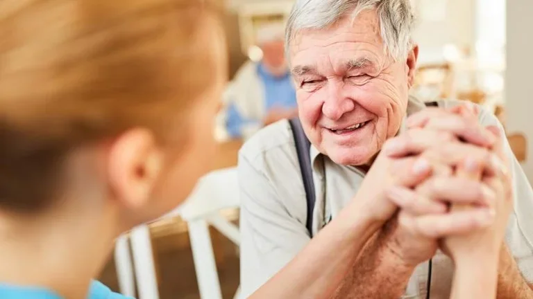 Senior drückt Hand von Besuchsdienst