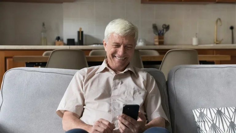 Lächelnder Senior aktiv am Handy