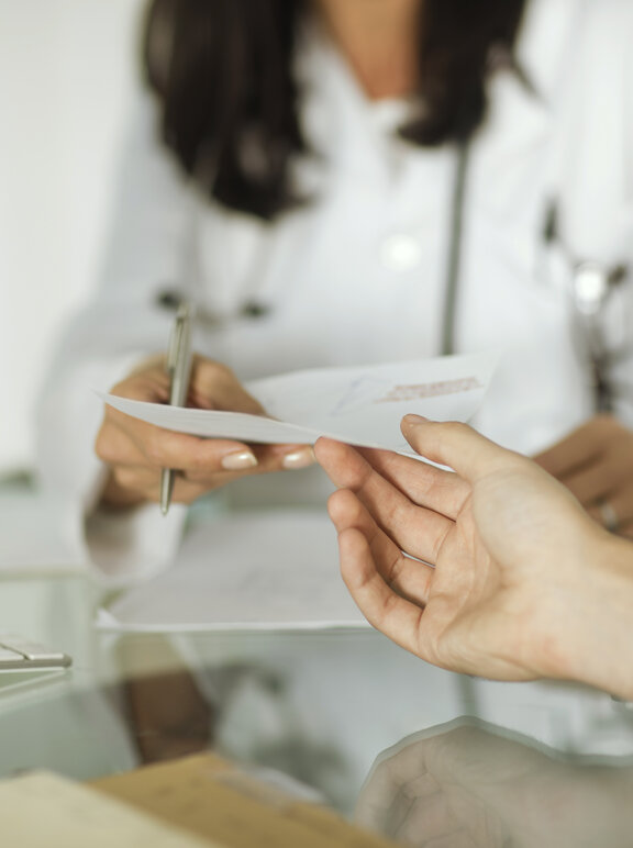 Ärztin überreich Patient Rezept für Insulinpumpe