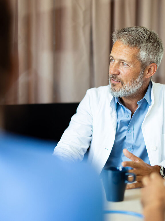 Arzt im Gespräch gestikuliert