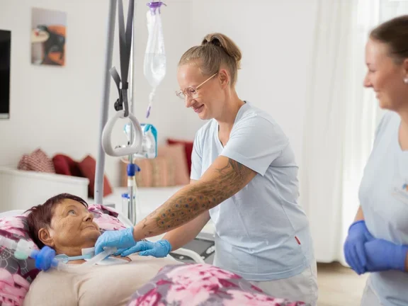 Außerklinische Intensivpflegerin mit Patientin am Bett