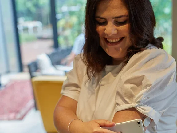 Frau misst mit ihrem Smartphone ihren Blutzucker