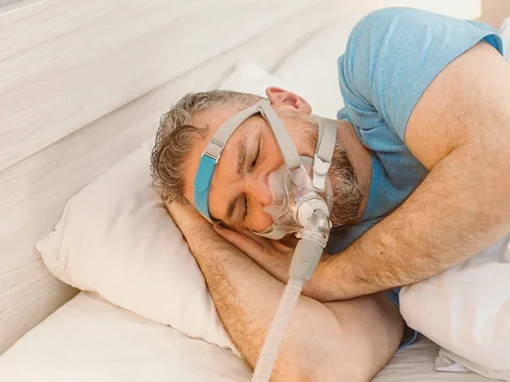 Ein Mann liegt mit einer Sauerstoffmaske auf einem Bett