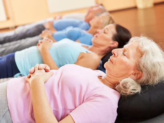 Patientinnen und Patienten meditieren im Liegen