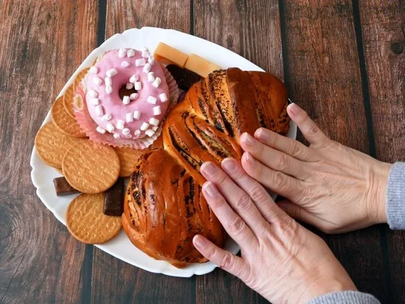 Hände schieben süßes Gebäck beiseite