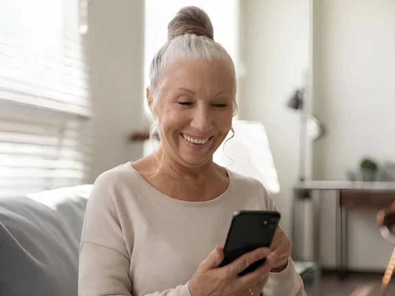 Lächelnde Seniorin am Smartphone