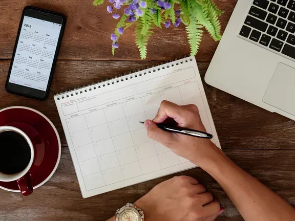 Tag organisieren: Kalender und Laptop 