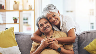 Älteres Pärchen kuschelt auf dem Sofa