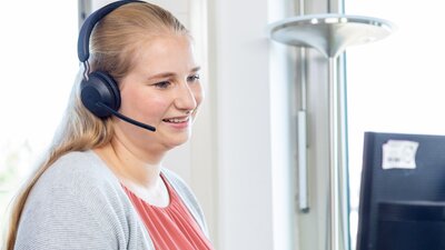 Eine Frau steht im Büro an einem Schreibtisch