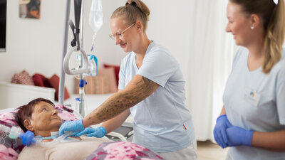 Außerklinische Intensivpflegerin mit Patientin am Bett