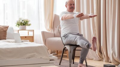 Mann macht Lungensport Übung im Sitzen