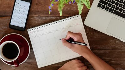 Tag organisieren: Kalender und Laptop 